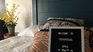 A bed with a sign that reads "WELCOME TO SEABATICAL OPEN May 11". - Large lock off room on the backside of our home, 2 miles from beaches. US1&PGA (North Palm Beach)