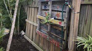 A wooden fence with signs saying "Plant Smiles," "Grow," "Harvest," and "Love." - Large lock off room on the backside of our home, 2 miles from beaches. US1&PGA (North Palm Beach)