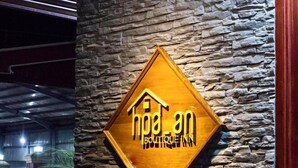 A sign for Boutique Inn with a stone wall background. - Hpa An Boutique Inn (Hpa-An)