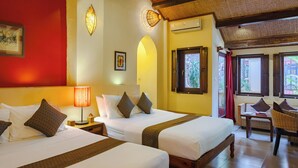 A hotel room with two beds, a wooden ceiling, and a view of greenery outside. - Rikitikitavi (Kampot)