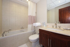 A bathroom with a bathtub, toilet, and sink.