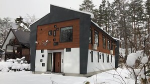 A modern building with a prominent entrance, large windows, and a sign that reads 'Salti.' - Salji (Hakuba)