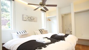 A bedroom with a bed, a ceiling fan, a window, and a door. - Salji (Hakuba)