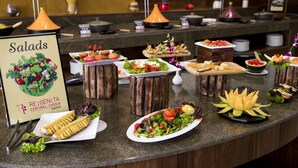 Un mostrador de buffet con ensaladas y diferentes platos.