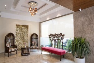 Un vestíbulo moderno con techo de madera, un muro decorativo, un ventanal grande y una planta en maceta.