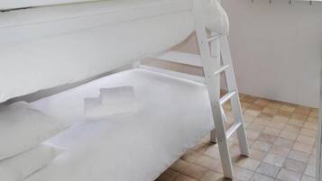 Dormitorio con literas, una escalera, una ventana con vistas a zonas verdes y una pared con diseño.