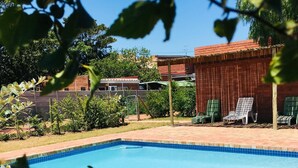 A swimming pool with a tiled edge, surrounded by a brick patio. - Addo River-View Lodge (Colchester)