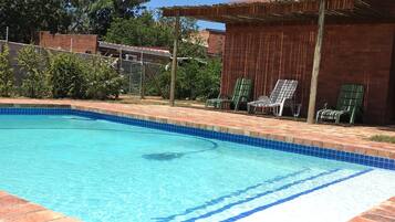 Una piscina con borde de azulejos y contorno de ladrillo.