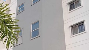 Un edificio de varios pisos con fachada plana, varias ventanas y un poste central.