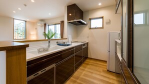 Eine moderne Küche mit einer langen Arbeitsplatte, einem eingebauten Backofen und einem Kühlschrank.