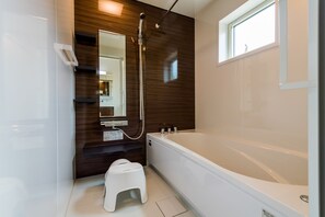 Villa | Badkamer | Een bad/douchecombinatie, een diep bad, gratis toiletartikelen