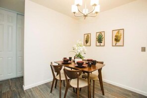 Enjoy meals in this inviting dining area with a wooden table and matching chairs, surrounded by framed botanical prints.