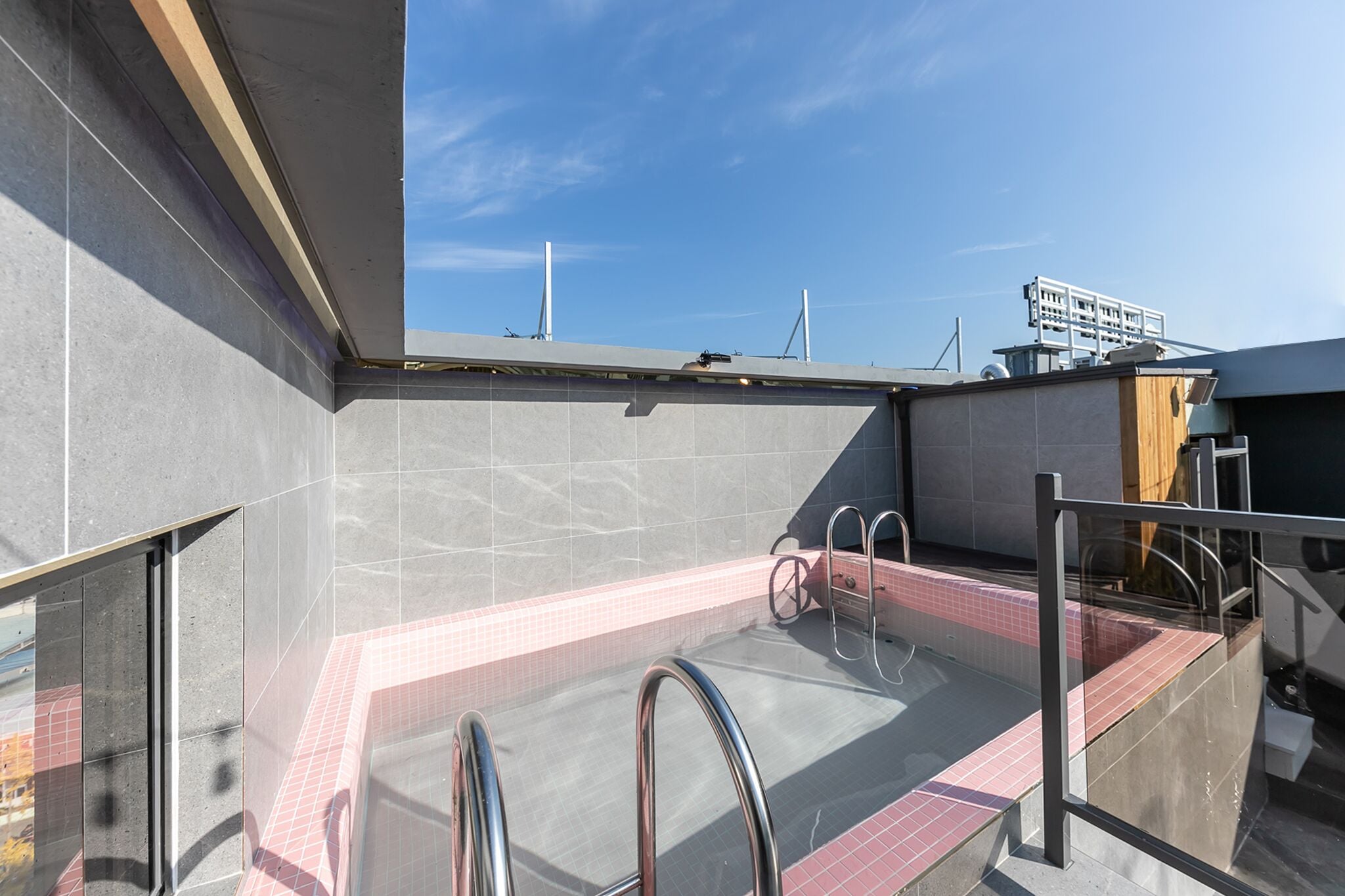 A rooftop pool area with a clear view of the sky and a modern architectural design.