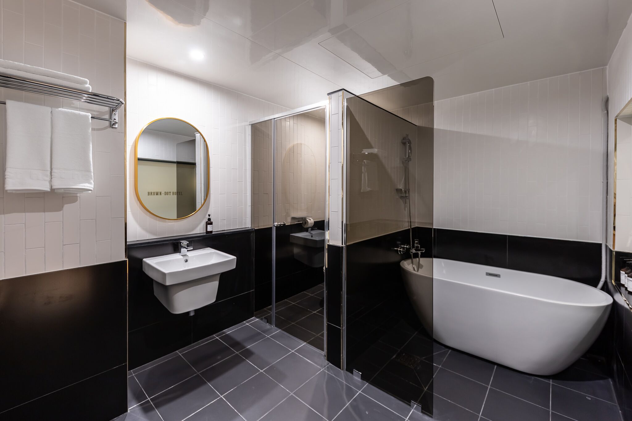 A modern bathroom with a freestanding bathtub, a sink, and a mirror.