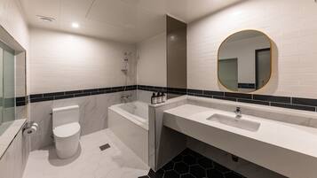 Un baño moderno con inodoro, bañera y dos lavamanos.