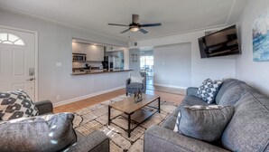 Ein modernes Wohnzimmer mit Sofa, Couchtisch und Deckenventilator.