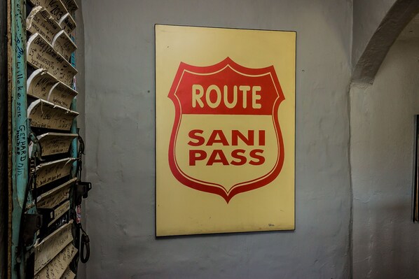 A wall with a sign that reads "ROUTE SANI PASS".