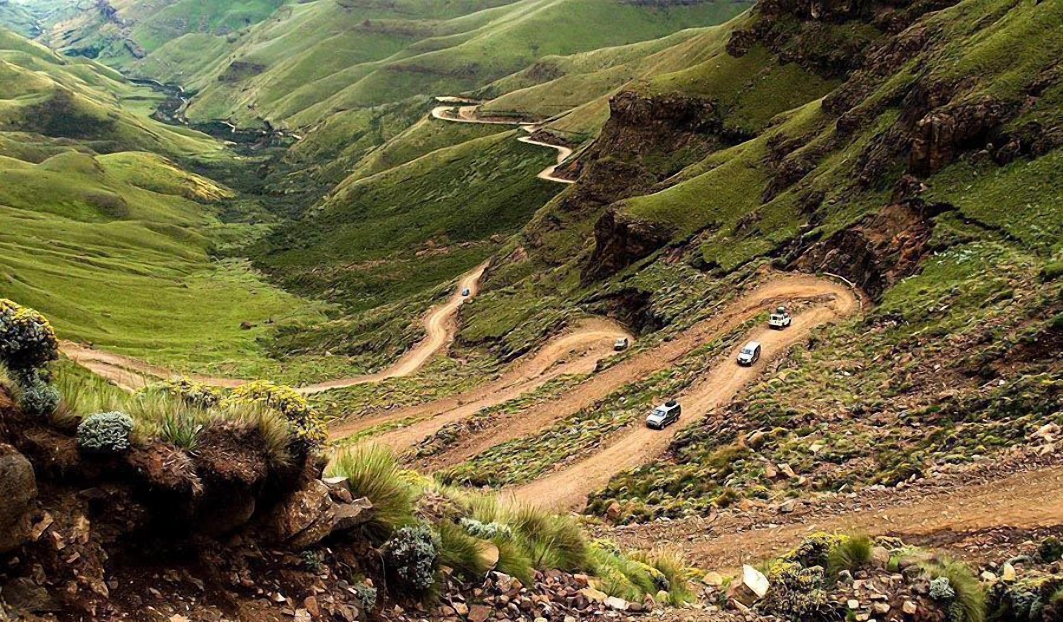 A winding mountain road with vehicles.