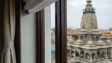 Vista de un complejo de templos a través de una ventana con cortinas.