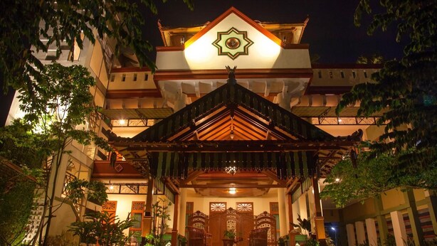 A traditional building with a prominent central entrance, ornate wooden gates, and a star-shaped emblem above the entrance. - Kotagede Heritage Homestay (Yogyakarta)