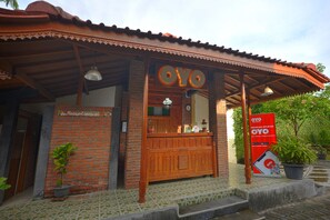 A reception area with a wooden counter, a sign reading "OYO", and a red banner advertising a special member benefit.