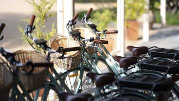 A row of bicycles with baskets and racks, parked outdoors.