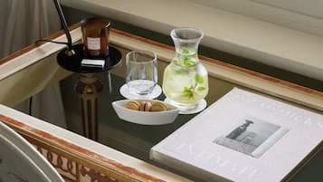 A desk with a lamp, a vase, a glass, and a framed picture.