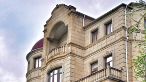 A multi-story building with a classical architectural style, featuring a prominent dome and multiple balconies.