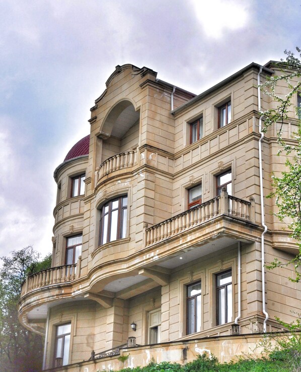 Un edificio de varios pisos con estilo arquitectónico clásico, que destaca por una cúpula imponente y varios balcones.