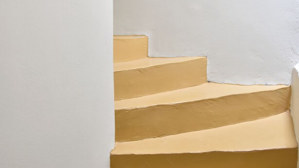 A set of beige stairs against a white wall. - Chalkidonos (Heraklion)