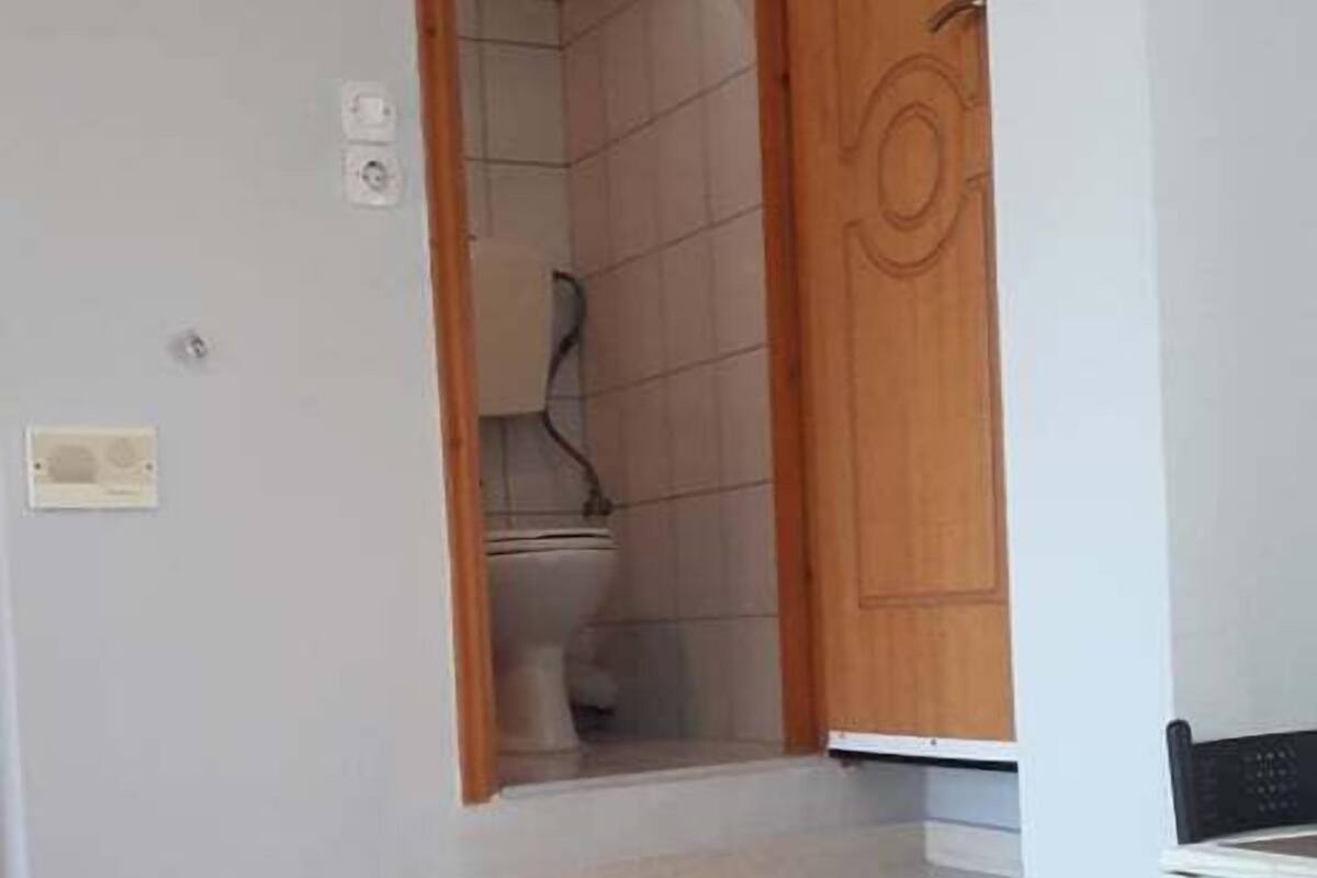 A staircase leading to a bathroom with a toilet and a shower.