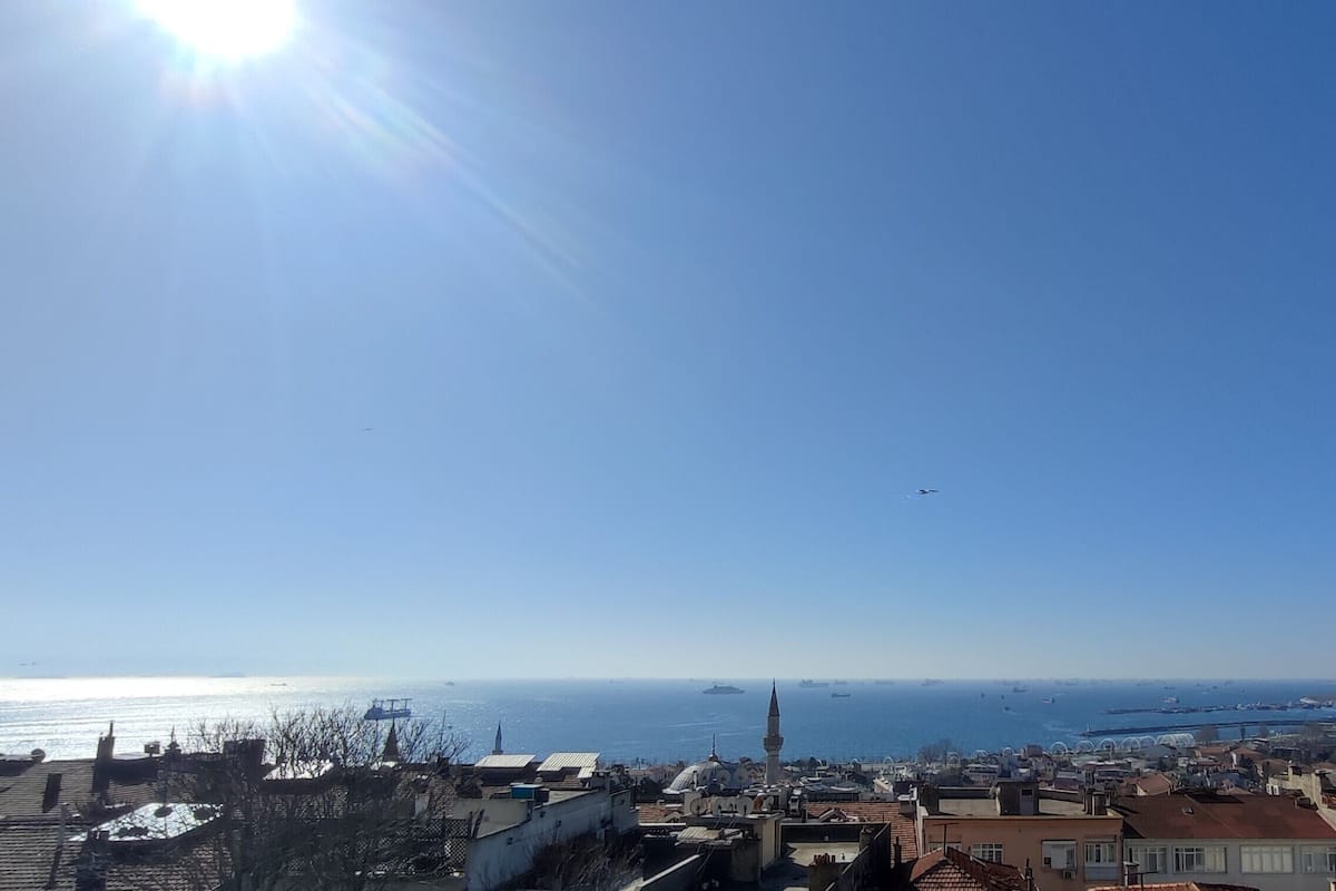 Un paisaje urbano costero con cielo despejado, edificios y el mar.
