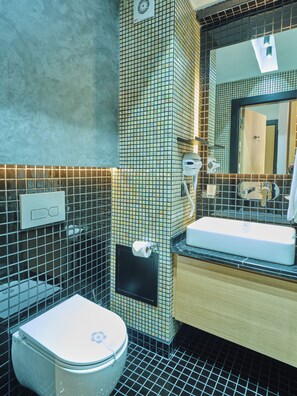 A bathroom with a toilet, sink, and mirror. - Four-G Hotel (Istanbul)