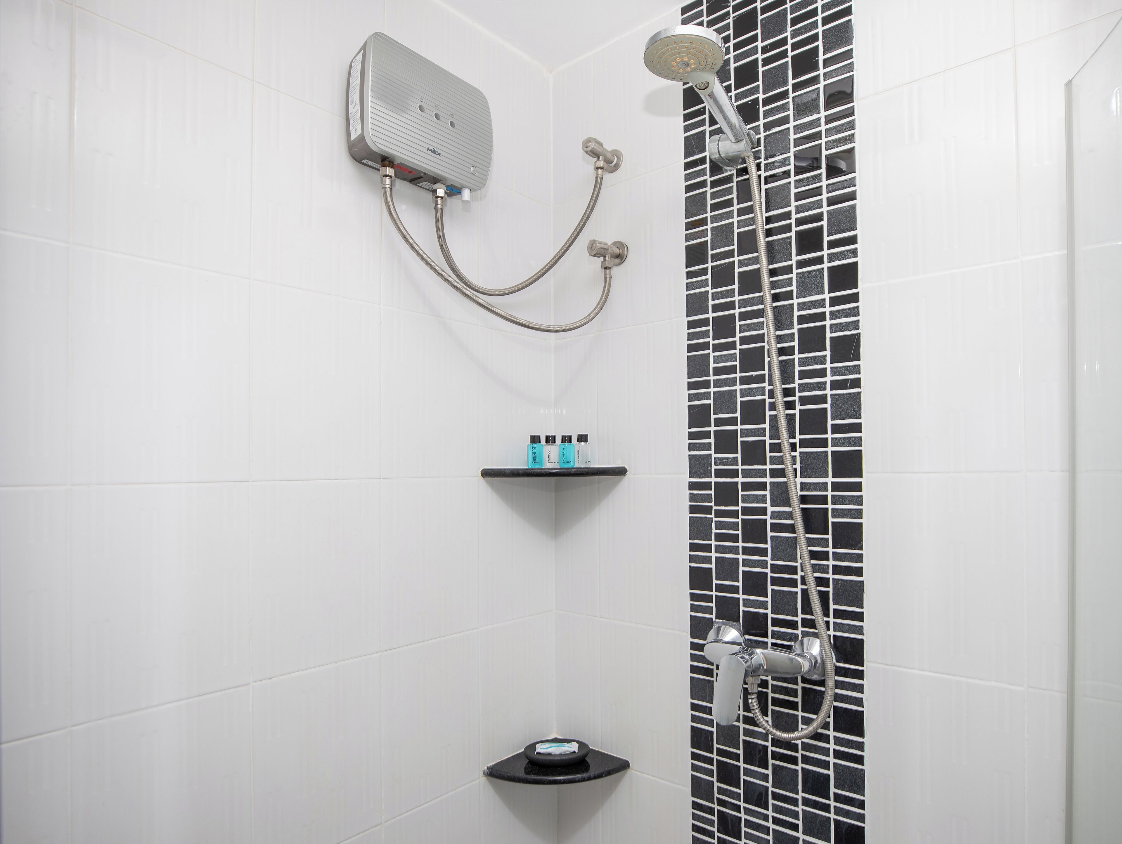 A shower with a handheld showerhead and a wall-mounted control panel.