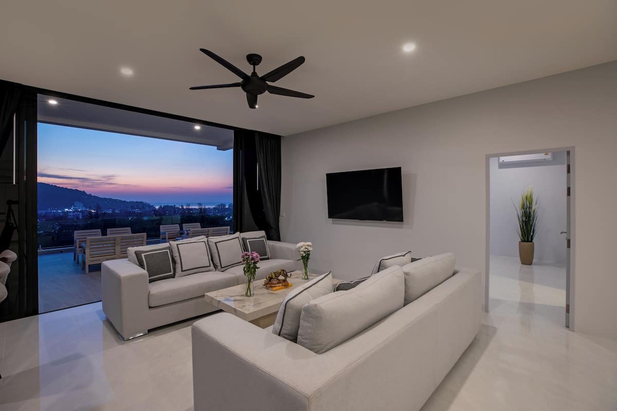 A modern living room with a sofa, coffee table, and a flat-screen TV.