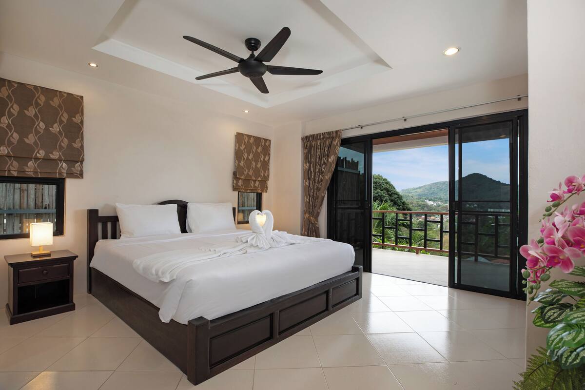 A bedroom with a bed, bedside table, and a ceiling fan.