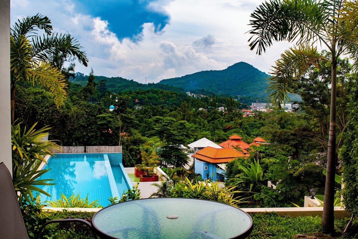 A pool area with a view of a mountainous landscape and residential buildings.