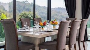 A dining table with six chairs, a fruit bowl, and wine glasses set for six. - Baan Chom View Kamala (Kamala)
