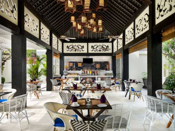 An indoor dining area with a central bar, white wicker chairs, and a ceiling with hanging lanterns. - Avani Vacation Club Seminyak Bali (Seminyak)