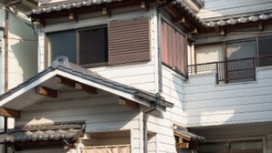 A traditional Japanese building with multiple levels, wooden beams, and a tiled roof. - Sano san chi (Izumisano)