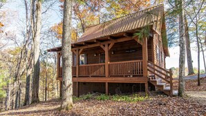 A rustic cabin with a wooden deck and a staircase leading to the entrance. - Sunrise Cabin- Hot Tub, WiFi, Firepit, Grill (Campton)