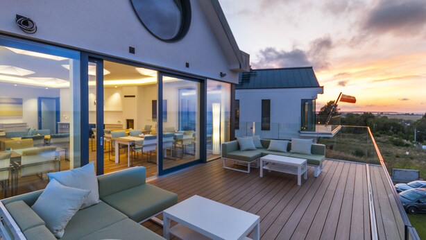 A modern outdoor deck with seating and a glass wall overlooking a scenic landscape. - Przystan Mechelinki - Marina del Mar (Kosakowo)
