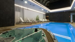A modern indoor swimming pool with a hot tub, lounge chairs, and recessed lighting. - Przystan Mechelinki - Marina del Mar (Kosakowo)