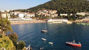 Une ville côtière dotée d’un port de plaisance, de bateaux et d’immeubles aux toits rouges.