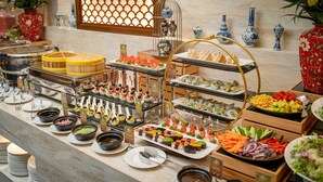 Un bufé con diversas opciones de comida y jarrones decorativos.