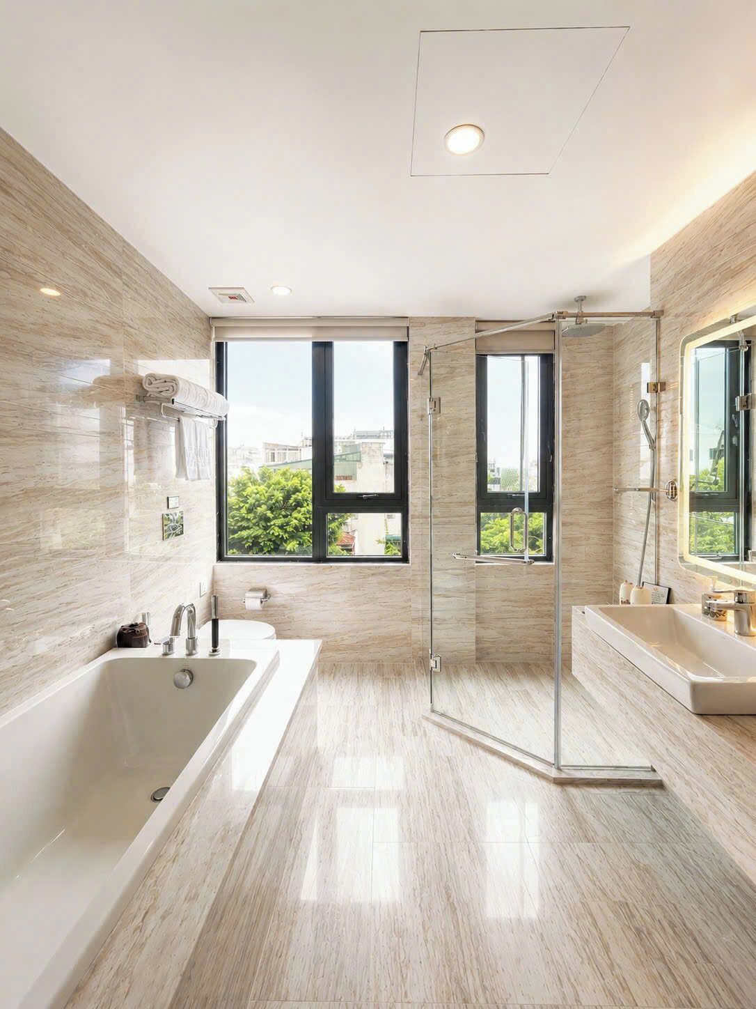 A modern bathroom with a large bathtub, a glass-enclosed shower, and a vanity with a mirror.