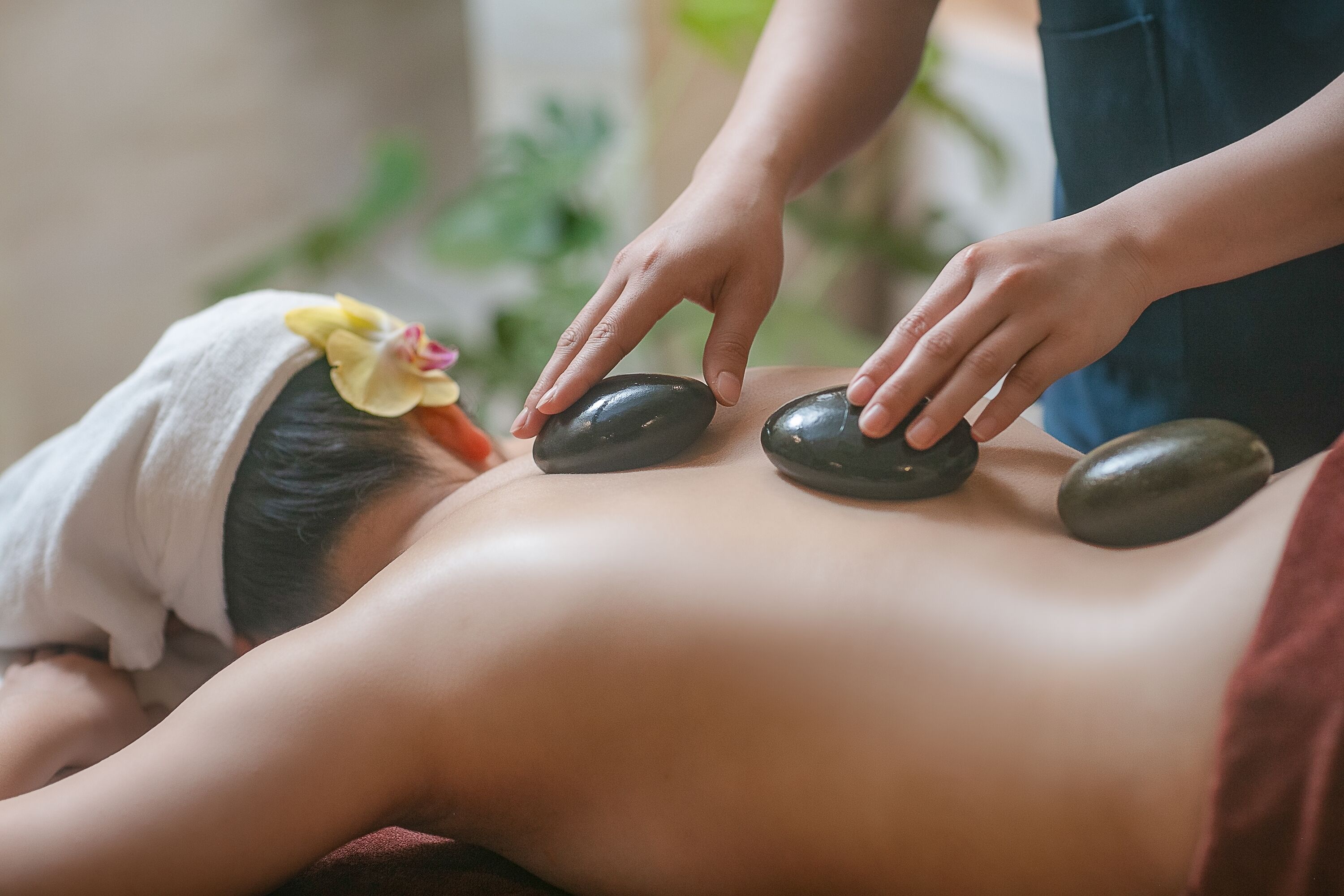 A person receiving a stone massage on their back.