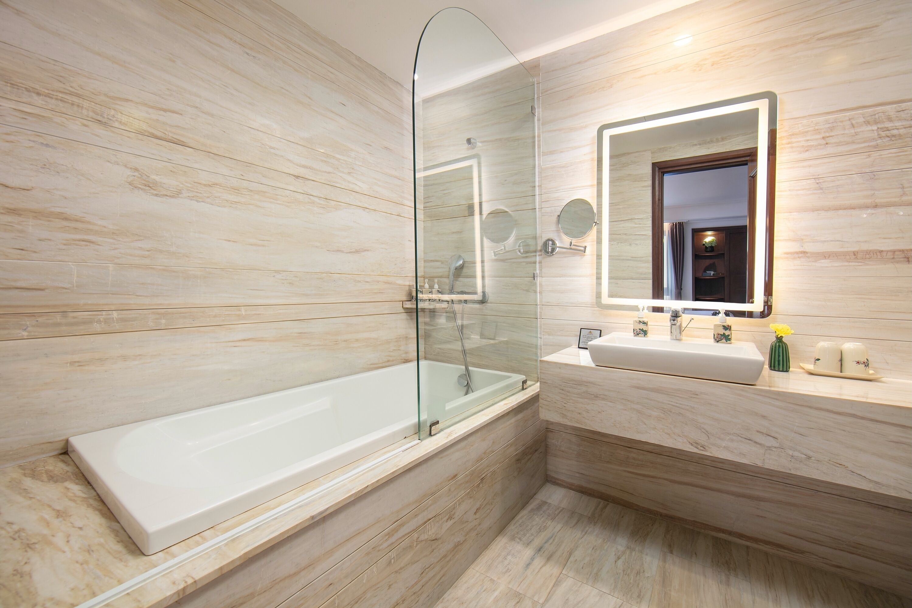 Une salle de bain moderne avec une douche à parois de verre, une grande baignoire et un meuble-lavabo avec un miroir.