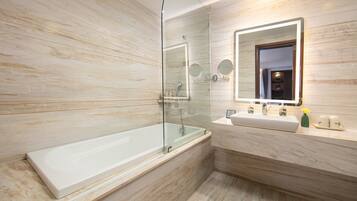 Une salle de bain moderne avec une douche à parois de verre, une grande baignoire et un meuble-lavabo avec un miroir.