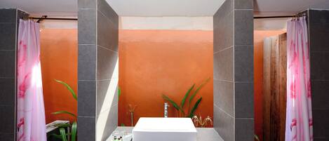 Une salle de bain avec un lavabo blanc, des carreaux gris et une porte en bois.